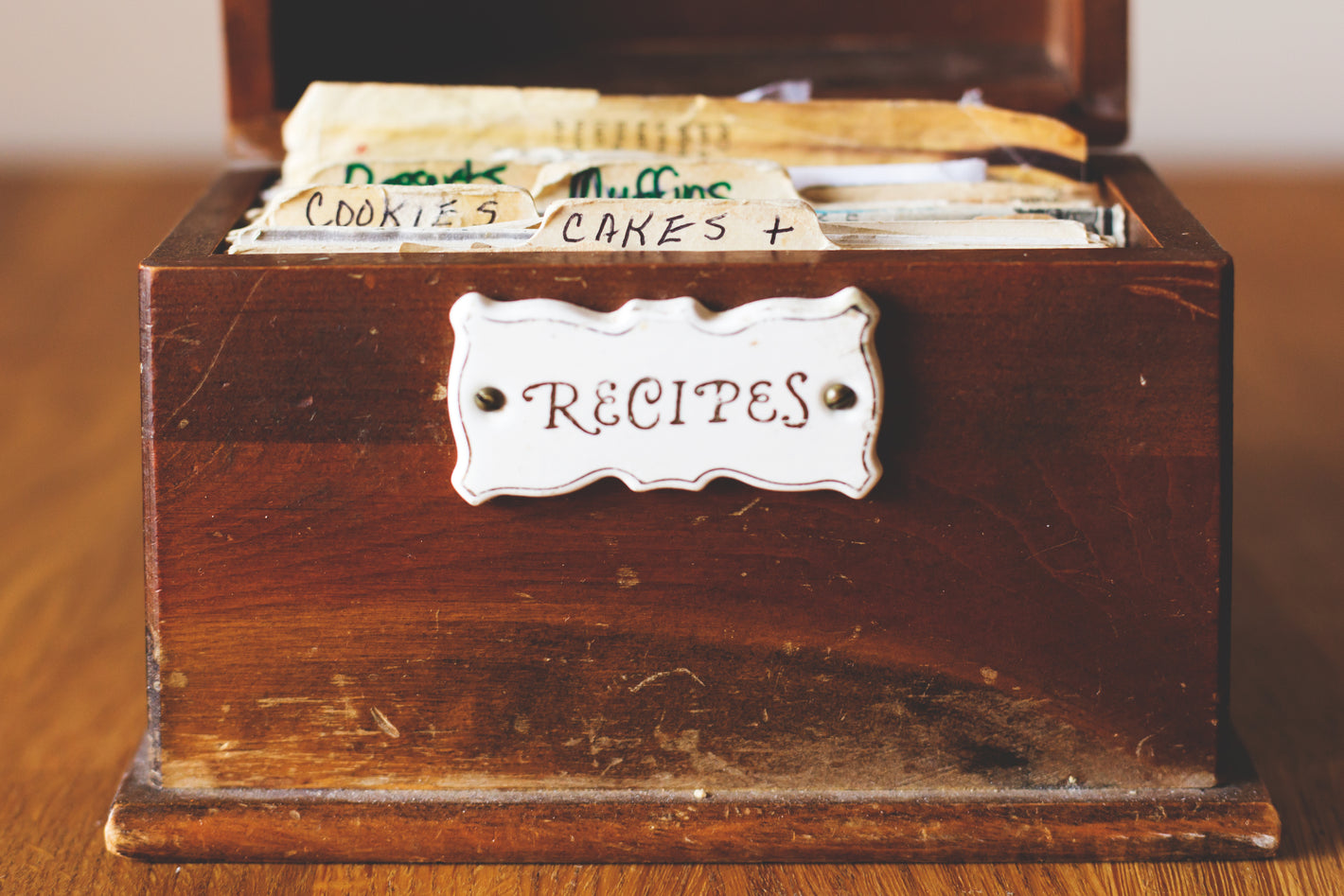 An old small well used wooden box holding index cards wih recipes.